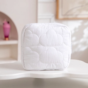 Detail of white quilted cloud pattern on soft portable travel storage cosmetic bag