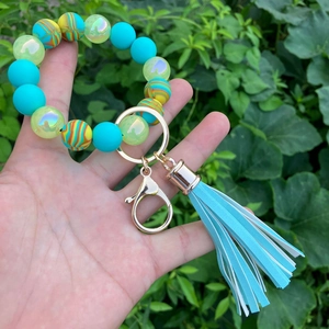 Detail of colorful silicone bead keychain with turquoise tassel and gold lobster clasp