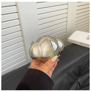 Close-up of a mini silver cloud-shaped metal shell bag with a mirror-like polished finish