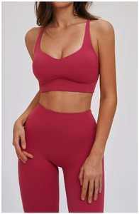 Detail van de dieproze yoga-beha met fijne bandjes en elastische V-hals ontwerp