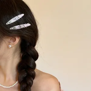 Set of lavender marble dog hair clips with 'egg' engraving worn on a braided hairstyle
