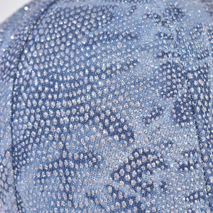 Macro detail of blue denim baseball cap with glitter coating and visible stitching