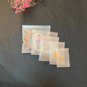 Waterproof frosted EVA storage bags for jewelry and beads on a grey textured background