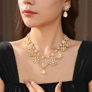 Détail du collier vintage doré et boucles d'oreilles papillon avec perles et strass
