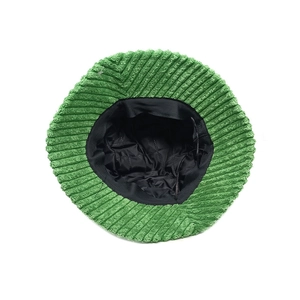 Detail view of green corduroy bucket hat showing quilted black lining and texture