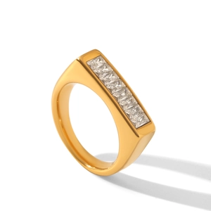 Detailed view of wide gold stainless steel ring set with five square-cut zircons