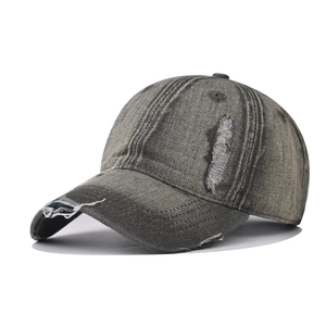 Detailed macro view of distressed denim fabric and ripped holes on vintage baseball cap