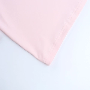 Close-up of double-needle stitching on the hem of a pink knitted mini dress
