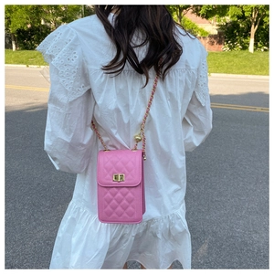 Detail of pink quilted cross-body phone bag with golden twist lock and chain strap