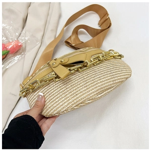 Detail of woven chest bag featuring brown PU leather trim and gold chain decoration