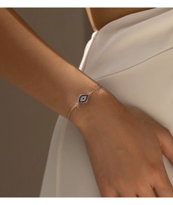Détail macro du bracelet œil protecteur en argent avec zircons bleus et blancs au poignet