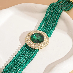 Macro shot of emerald green beaded necklace with sparkling rhinestone crystal pendant