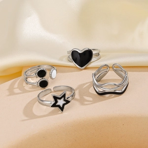 Set of four geometric stainless steel rings with black and white drip oil details