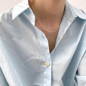 Close-up of minimalist 925 sterling silver twisted chain necklace worn by a model
