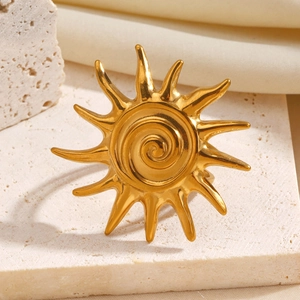 Vintage gold sunburst ring with spiral core and radiant rays on travertine stone