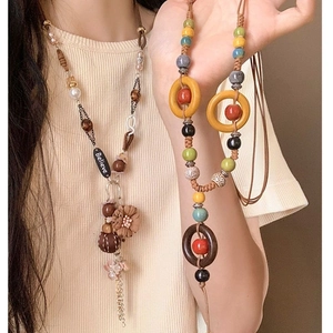 Detail of bohemian necklace with colorful ceramic beads, wooden rings and Believe pendant
