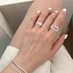 Detail shot of 925 sterling silver chain rings and minimalist bracelets on model