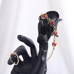 Resin hand model displaying gold ring and red heart gemstone bracelet set