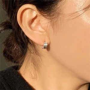 Close-up of a model wearing minimalist silver multi-layer striped hoop earrings