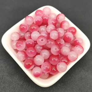 Close-up of 8mm pink and white gradient round glass beads in a white bowl for DIY jewelry