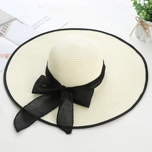 Chapeau de soleil en paille crème avec ruban nœud noir et large bord pour les vacances