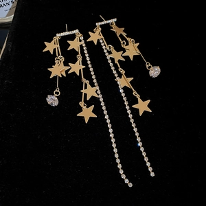 Gros plan détaillé de boucles d'oreilles étoiles dorées avec strass et longues franges