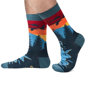 Detail of knit socks featuring a scenic mountain landscape design and orange sunset