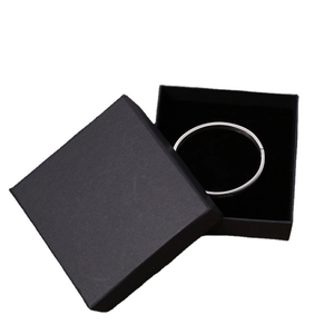 Bracelet en métal argenté minimaliste présenté dans un coffret cadeau noir et carré
