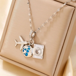 Detail of silver travel-themed necklace with airplane globe and zircon pendant in box