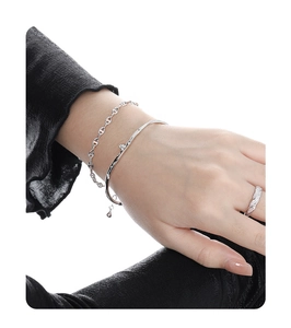 Detailed view of silver jewelry set including pig-nose chain, slim cuff, and paved ring