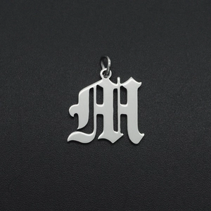 Detailed view of silver gothic letter M pendant in polished stainless steel for DIY jewelry