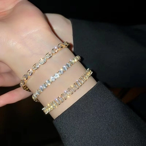 Detailed view of layered gold tennis bracelets with AAA zirconia and emerald-cut stones