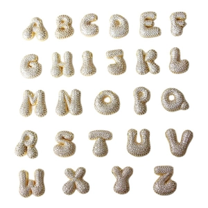 Golden balloon style A-Z alphabet pendants with sparkling pavé crystals on white background