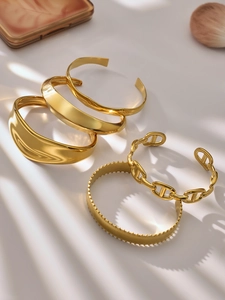 Detalle de los brazaletes irregulares bañados en oro de 18k con diseño de cadena de cerdo
