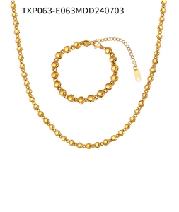 Dettaglio del set collana e bracciale a catena con sfere dorate e chiusura a moschettone