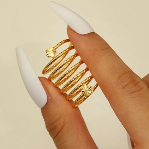 Detailaufnahme eines goldfarbenen Spiralrings mit Blumenmotiven und Hammerschlag-Textur