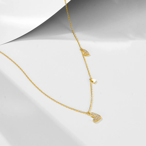 Macro shot of gold heart pendant with sparkling zircons and delicate chain details