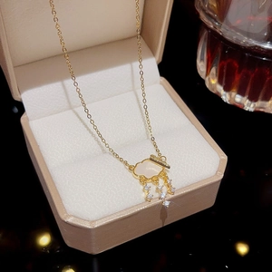Detail of a gold cloud pendant with white zircon raindrops in a jewelry box