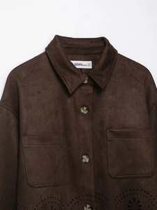 Détail d'une veste en daim marron avec ourlet découpé au laser et poches avant boutonnées