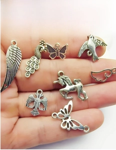 Nahaufnahme von Vintage-Silberanhängern mit Schmetterlings-, Pfau- und Flügelmotiven