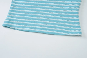 Macro detail of sky blue striped knitted fabric showing fine mesh texture and hem stitching