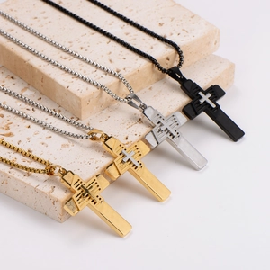 Retro stainless steel cross necklaces in silver gold and black displayed on stone steps