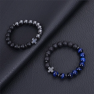 Close-up of black matte lava stone bracelets with blue cat eye beads and cross pendant