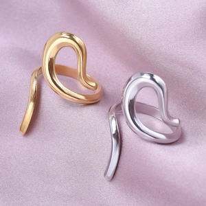 Close-up of gold and silver irregular geometric rings on soft purple silk fabric