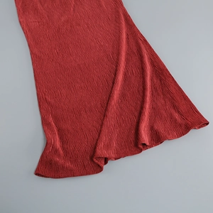 Close-up detail of high-quality red pleated fabric texture on a skirt