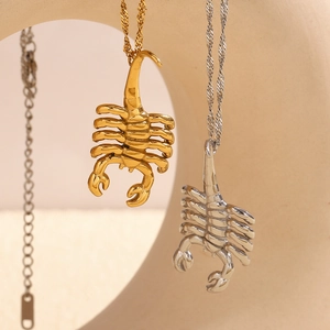 Scorpion pendant necklaces in gold and silver finish hanging on minimalist display