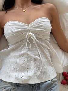 Detailed view of white lace tube top featuring intricate embroidery and front drawstring