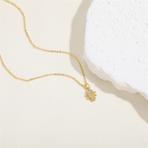 Macro detail of a 14K gold-plated ballet girl pendant necklace with sparkling zircons