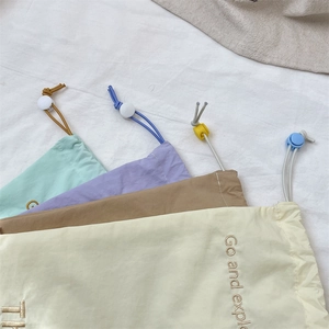 Close-up of drawstring organizer bags with Go and explore embroidery and round buckles