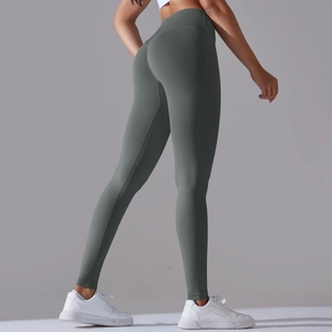 Detail of cross waist design and seamless knit texture on dark green yoga leggings